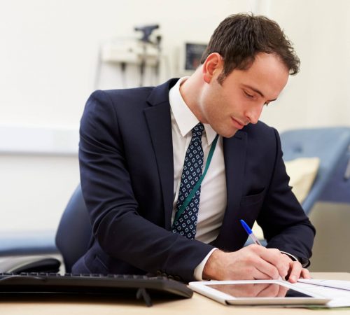 Male Consultant Working At Desk In Office